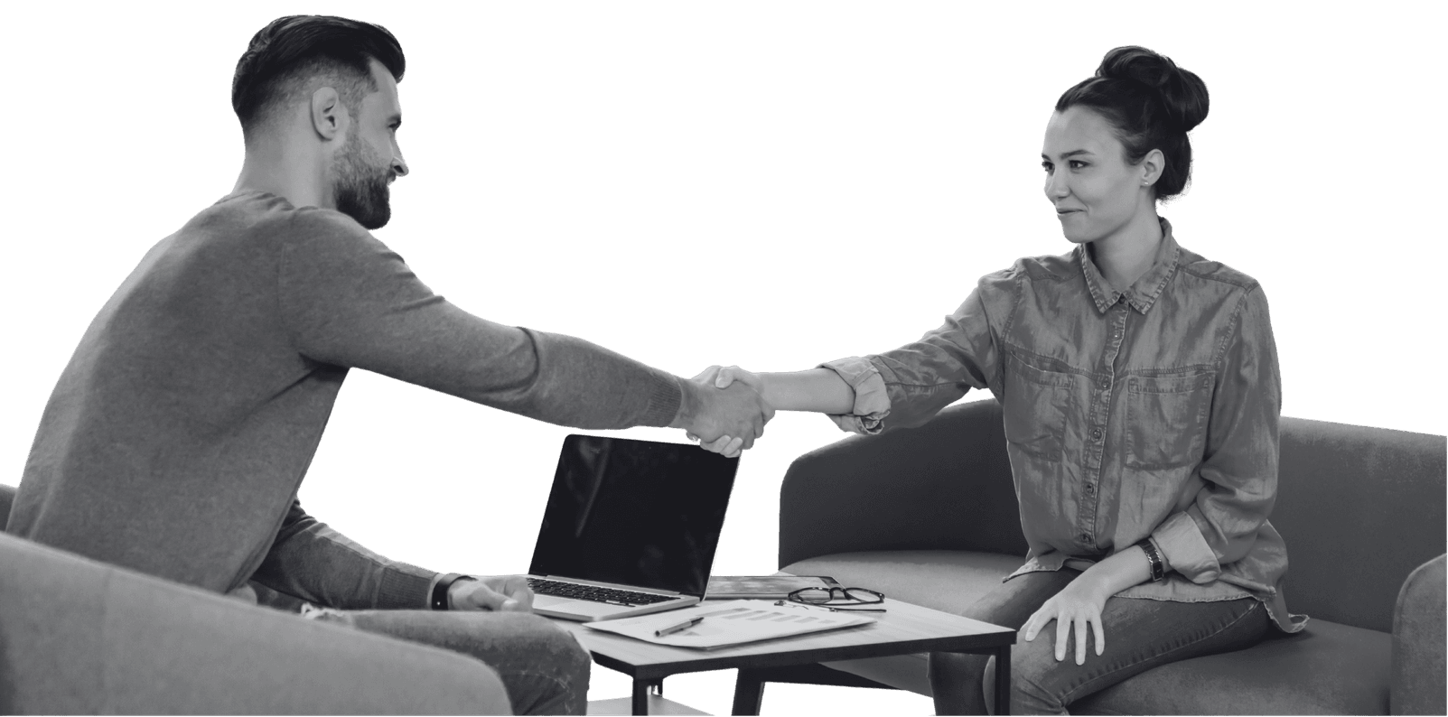 Two colleagues shaking hands across a table