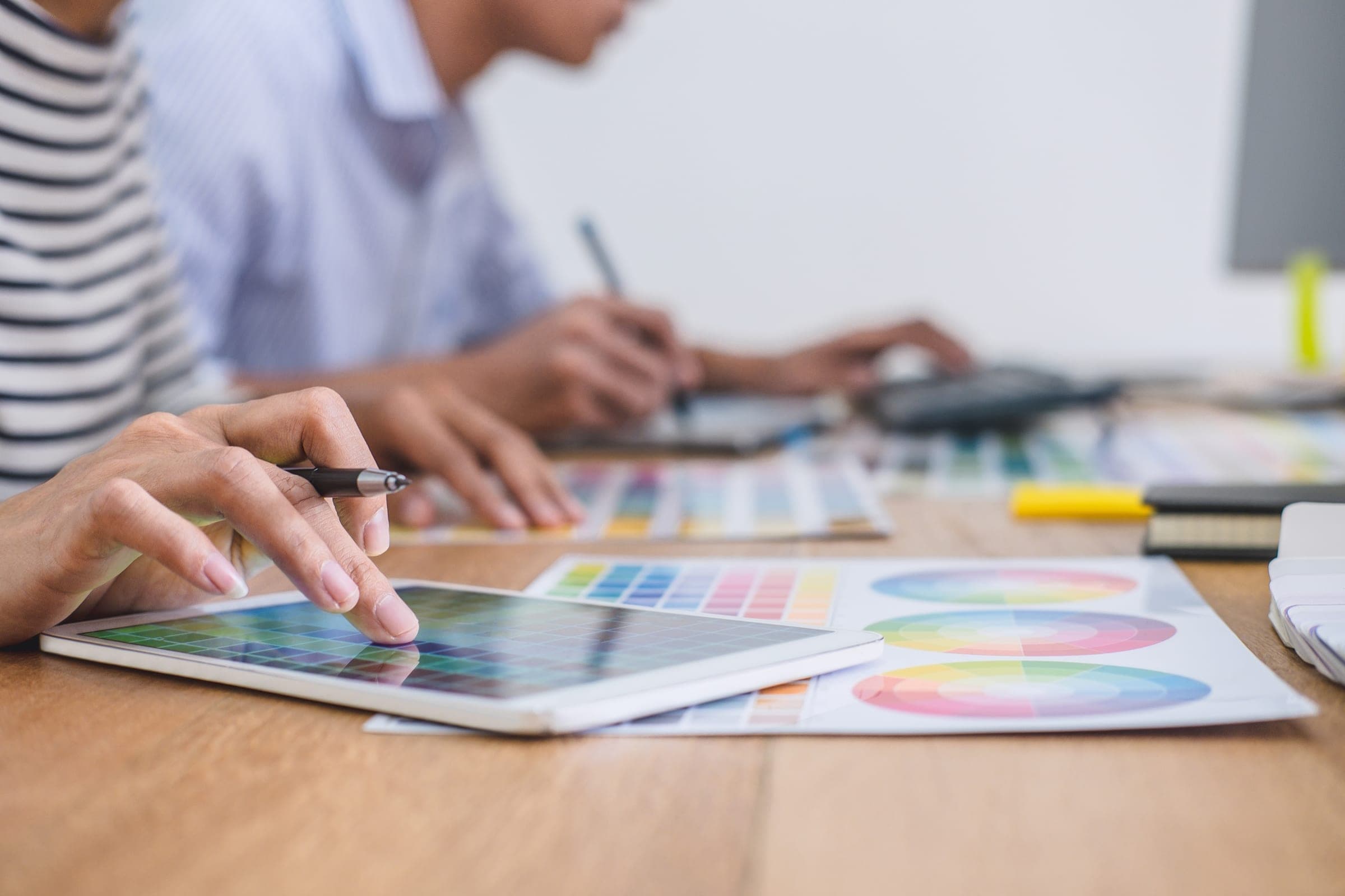 A creative team applying the brand around colour swatches