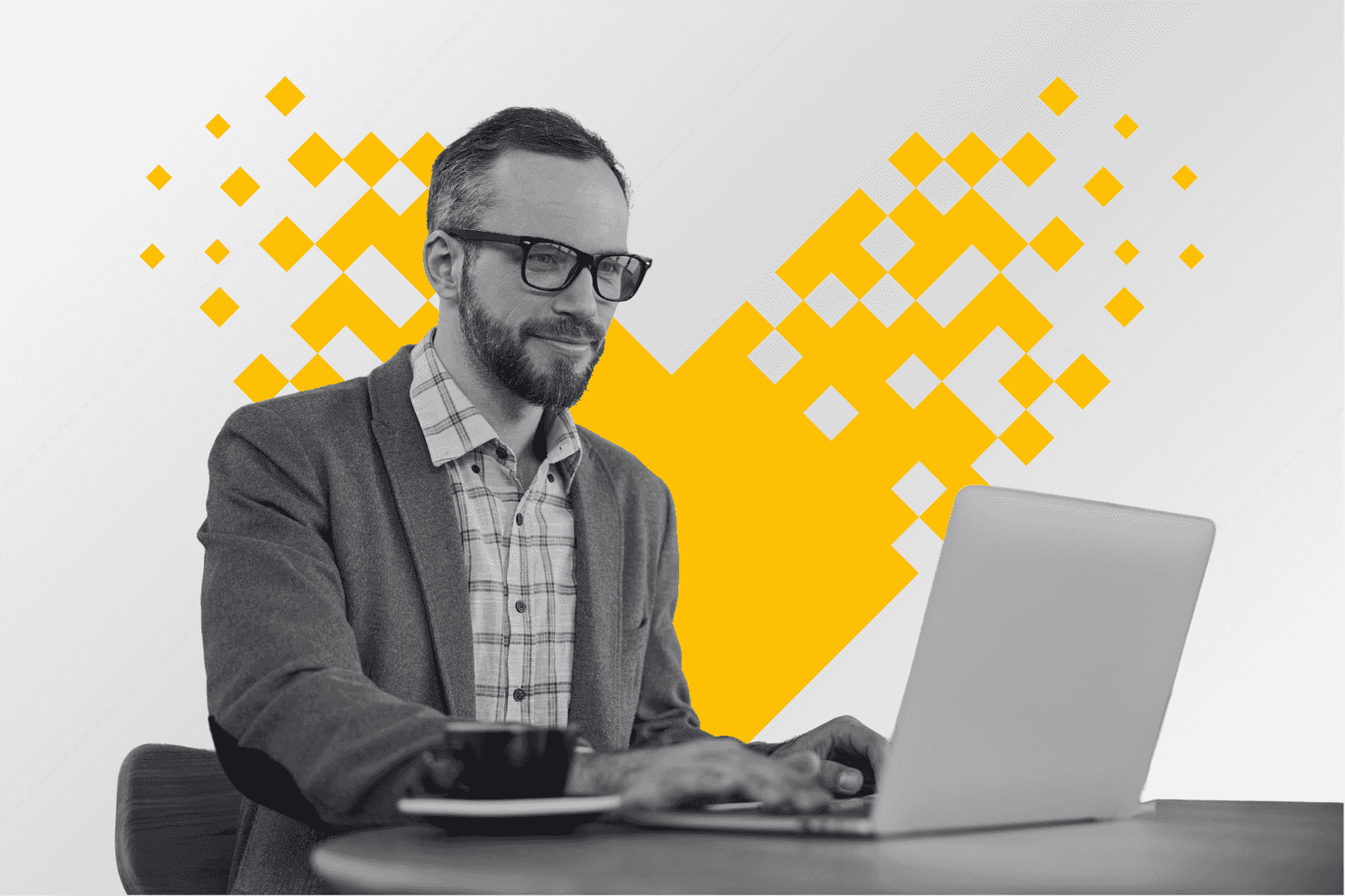 A professional working at a laptop with coffee framed by a pixel mosaic heart in yellow